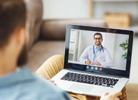 A man watching a medical video on a laptop