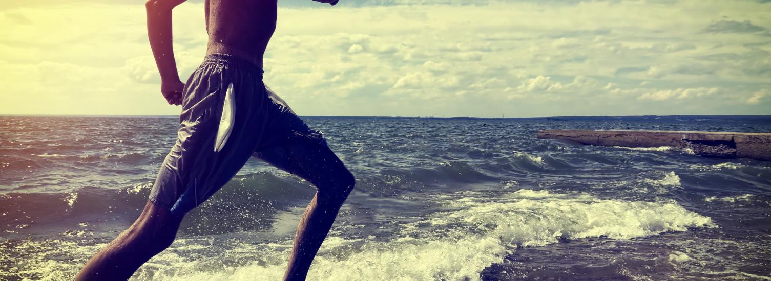 Man running on beach at ocean