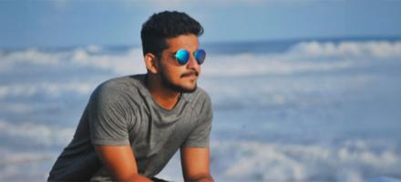 A man on the beach wearing sunglasses.